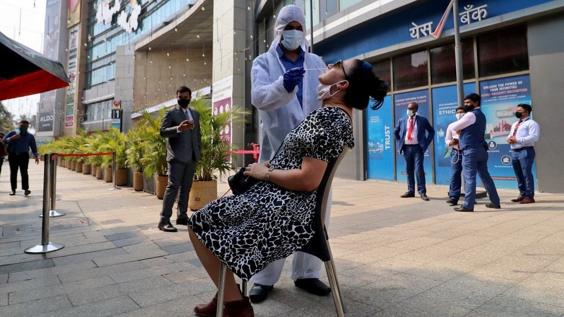 A healthcare worker collects a swab sample from a woman during a rapid antigen testing campaign for coronavirus, outside a shopping mall in Mumbai, India, on March 22, 2021. (Reuters)