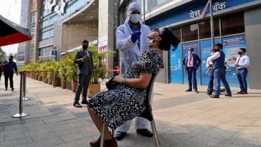 A healthcare worker collects a swab sample from a woman during a rapid antigen testing campaign for coronavirus, outside a shopping mall in Mumbai, India, on March 22, 2021. (Reuters)