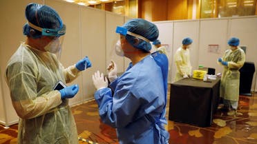 Medics are seen at a coronavirus disease test center at Geo Connect Asia trade conference in Singapore March 24, 2021. (Reuters/Edgar Su)