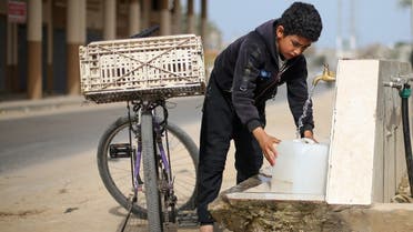 A Palestinian boy fills a container with water from a public tap On World Water Day, in the Gaza Strip March 22, 2021. (Reuters)