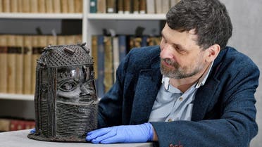 Neil Curtis, Head of Museums and Special collections is seen with one of the Benin bronze depicting the Oba of Benin at The Sir Duncan Rice Library, the University of Aberdeen, in Aberdeen, Scotland, Britain, on March 17, 2021. (Reuters)