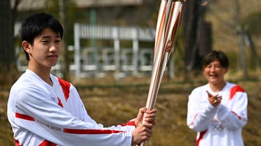 Japanese high school student Asato Owada carries the Olympic torch ahead of the Tokyo 2020 Olympic Games during the torch relay grand start outside the J-Village National Training Centre in the town of Naraha, Fukushima Prefecture on March 25, 2021. (File photo: AFP)