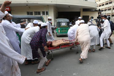 Activists of the Hifazat-e Islam group carry an injured activist on a stretcher outside the Chittagong medical college hospital in Chittagong on March 26, 2021 following clashes with police during a demonstration against Indian Prime minister Narendra Modi's visit to Bangladesh. (AFP)