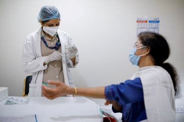 A woman watches as a healthcare worker fills a syringe with a dose of COVISHIELD, the coronavirus disease vaccine manufactured by Serum Institute of India, at Max Super Speciality Hospital, in New Delhi, India, on March 17, 2021. (Reuters)