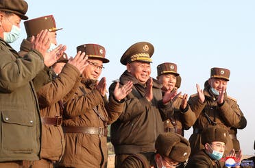 Ri Pyong Chol, the senior leader who is overseeing the test, and other military officials applaud after the launch of a newly developed new-type tactical guided projectile on March 25, 2021. (Reuters)