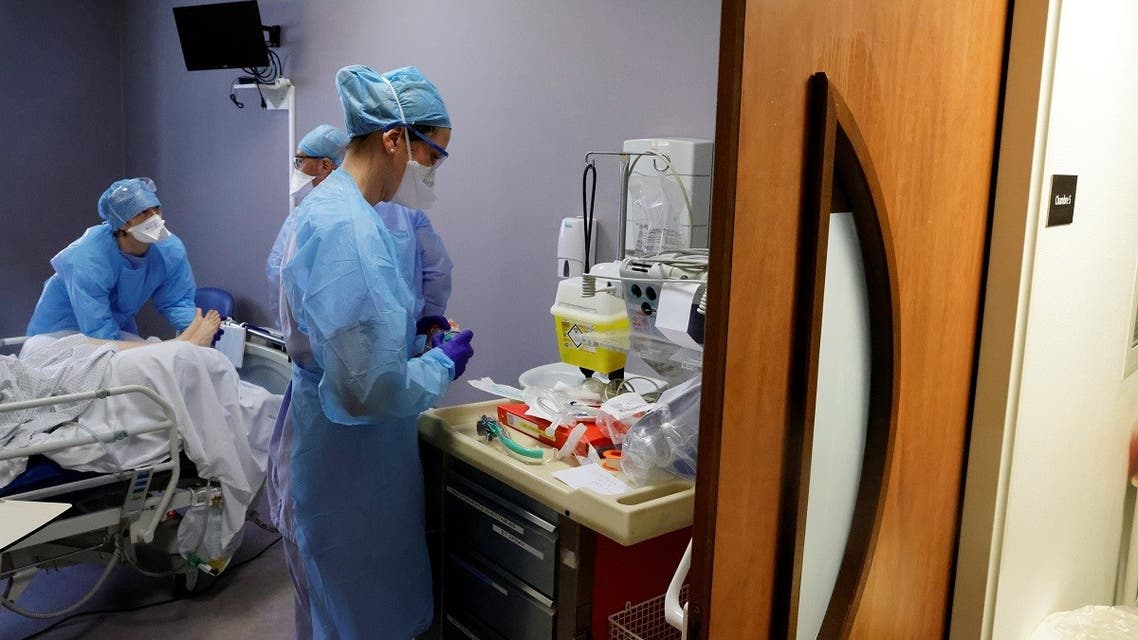 Medical workers, wearing protective suits and masks, work in the Intensive Care Unit (ICU) where people suffering from coronavirus disease (COVID-19) are treated at Cambrai hospital, France, on March 25, 2021. (Reuters)