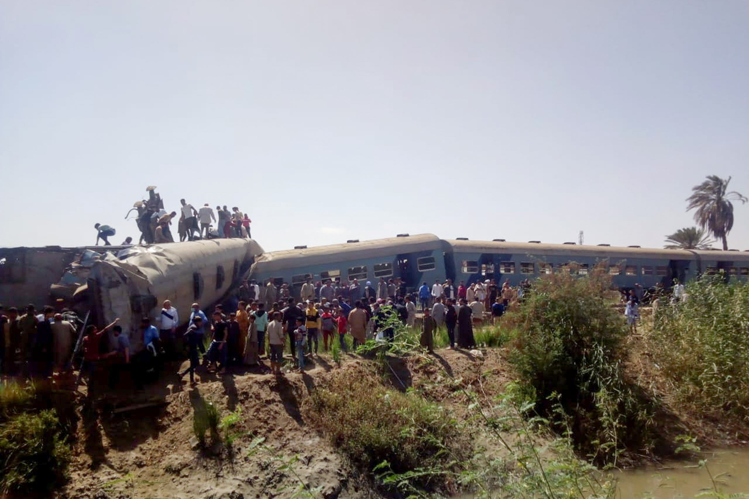 People inspect the damage after two trains have collided near the city of Sohag. (Reuters)