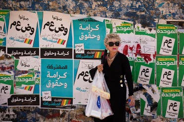 A woman stands in front of "Joint List" and "Meretz" party election campaign posters ahead of the March 23 ballot in the northern Israeli-Arab city of Nazareth March 13, 2021. Picture taken March 13, 2021. (Reuters)
