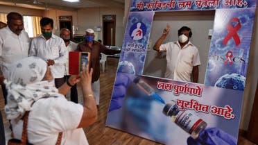 A man poses behind a cardboard cut-out with the words “I have taken the vaccine, it’s completely safe” after receiving a dose of COVISHIELD coronavirus vaccine manufactured by Serum Institute of India, at a hospital in Satara district in the western state of Maharashtra, India, on March 24, 2021. (Reuters)