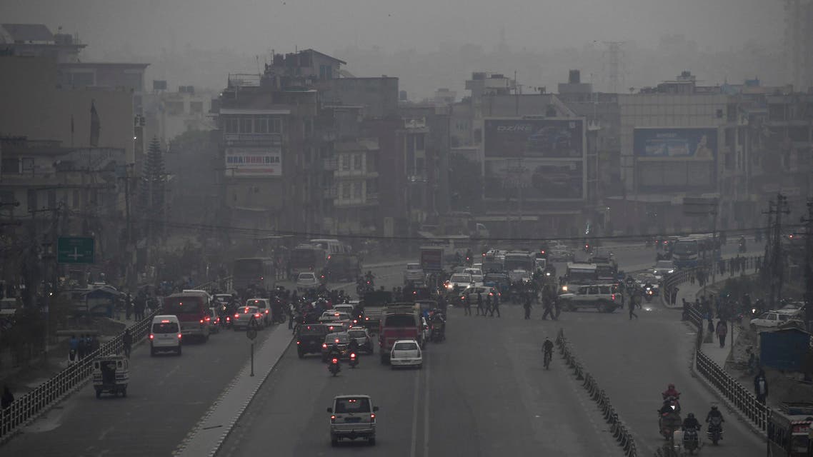 Commuters make their way along a road amid smoggy conditions in Kathmandu on March 29, 2021. (AFP)