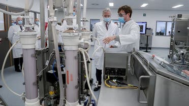 Belgian King Philippe listens the explanations on LNP (Lipid Nano Particle) SKID machine during a visit to a factory producing the Pfizer-BioNTech COVID-19 vaccine in the town of Puurs, Belgium, on March 30, 2021. (Reuters)