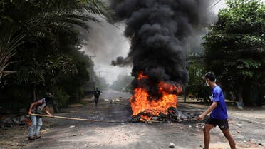 An anti-coup protester walks past burning tires after activists launched a garbage strike against the military rule, in Yangon, Myanmar March 30, 2021. (File photo: Reuters)