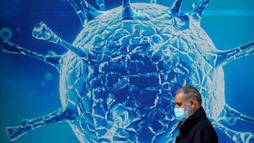 FILE PHOTO: A man wearing a protective face mask walks past an illustration of a virus outside a regional science centre in Oldham, Britain August 3, 2020. (File photo: Reuters)
