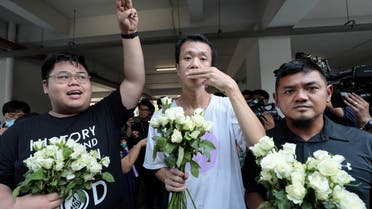 (L-R) Bunkueanun Francis Paothong, 21, Ekachai Hongkangwan, 45, and Suranat Panprasert, 35, flash three fingers salutes as they turn up at the attorney general's office after being on charges of attempted violence against the queen during a pro-democracy demonstration last year, when a royal motorcade encountered dozens of protesters, in Bangkok, Thailand March 31, 2021. (Reuters)