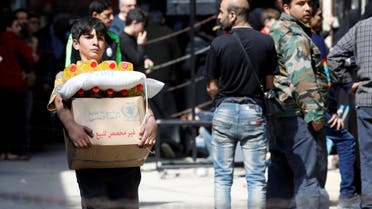  A boy holds a cardboard box of food aid received from World Food Programme in Aleppo's Kalasa district, Syria April 10, 2019. Picture taken April 10, 2019. REUTERS/Omar Sanadiki
