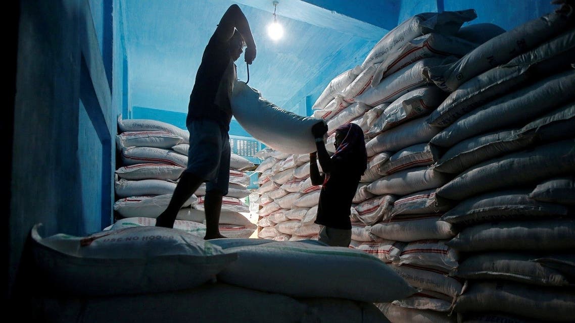 Laborers lift a sack filled with sugar to load it onto a handcart at a wholesale market in Kolkata, India. (Reuters)