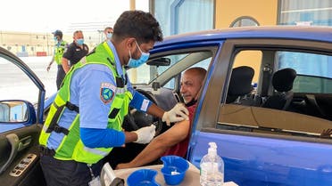 A health worker inoculates a man against the coronavirus at a drive-through vaccination centre in the city of al-Wakrah, north of the capital Doha, on March 31, 2021. (AFP)