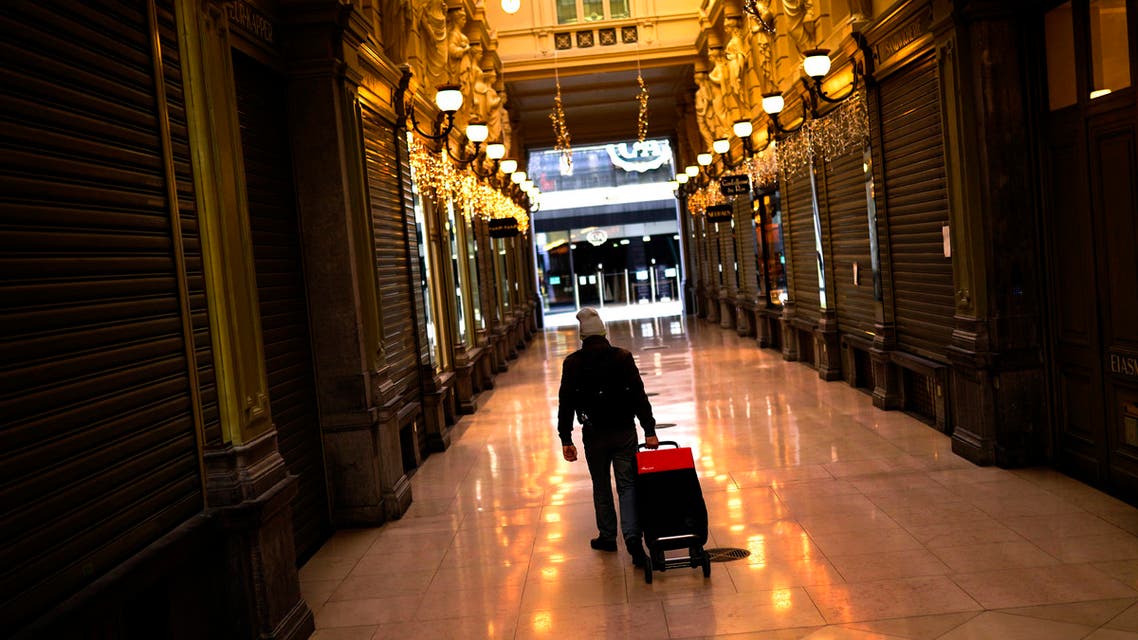 A man pulls a trolley next to closed shops in a commercial street during a partial lockdown due to the coronavirus COVID-19 in downtown Brussels, Friday, Nov. 20, 2020. (AP)