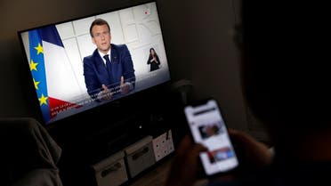 A man watches French President Emmanuel Macron on a TV screen, at his home in Saint-Sebastien-sur-Loire as Macron addresses the nation about the state of the coronavirus disease (COVID-19) outbreak as a fast-spreading third wave of COVID-19 infections threatens to over-run hospitals in France. (Reuters)