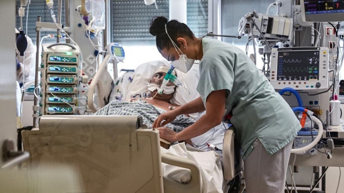 A member of the medical staff gives medication to a patient infected with Covid-19 at the intensive care unit of the Andre-Gregoire intercommunal hospital, in Montreuil, Seine-Saint-Denis, on the outskirts of Paris, on April 1, 2021. (AFP)