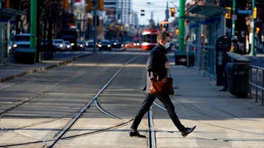 A man walks with a face mask on the one-year anniversary of the World Health Organization declaring coronavirus disease (COVID-19) a pandemic in Toronto, Ontario, Canada March 11, 2021. (Reuters)