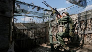 A militant of the self-proclaimed Donetsk People's Republic (DNR) points a weapon at fighting positions on the line of separation from the Ukrainian armed forces south of the rebel-controlled city of Donetsk, Ukraine April 2, 2021. REUTERS/Alexander Ermochenko