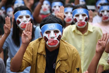 this handout from the Burma Associated Press (BAP) taken and received on April 4, 2021 shows protesters making the three-finger salute while wearing masks that express what they say is Chinese interference in the UN's handling of Myanmar affairs after the military coup in Yangon's Kamayut township. (File photo: AFP)