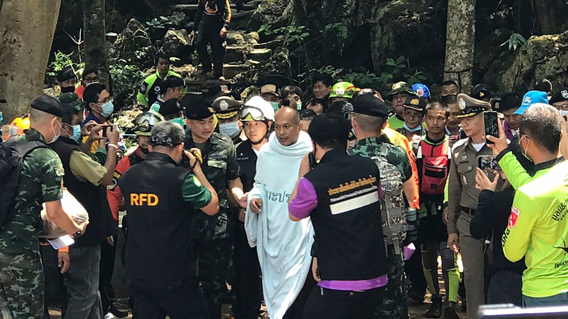 escuers help Phra Manas, center, walk out from the Tham Phra Sai Ngam cave in northern Thailand's Phitsanulok province, Wednesday, April 7, 2021. (AP)