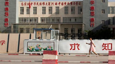 In this Aug. 31, 2018, file photo, a woman walks past the Kashgar Dongcheng No. 4 Junior Middle School, which is part of a cluster of schools with slogans which read, Study hard to realize the Chinese dream of the great rejuvenation of the Chinese nation, Kind Learning, Kind Thoughts, Kind Actions, and Pursue Knowledge, on the outskirts of in Kashgar, western China's Xinjiang region. (File photo: AP)