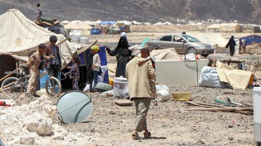 A man walks carrying a child at a camp for internally displaced people about 10 kilometres on the outskirts of Yemen's northeastern city of Marib on March 28, 2021, as residents of the camp prepare to flee due to its proximity with battles between forces of the Huthi-rebels and the Saudi-backed government troops.