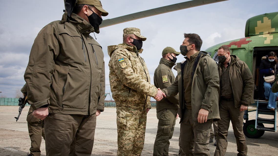 Ukraine's President Volodymyr Zelenskiy shakes hands with a serviceman during his working trip to the frontline with Russian-backed separatists in Donbass region, April 8, 2021. (Reuters)