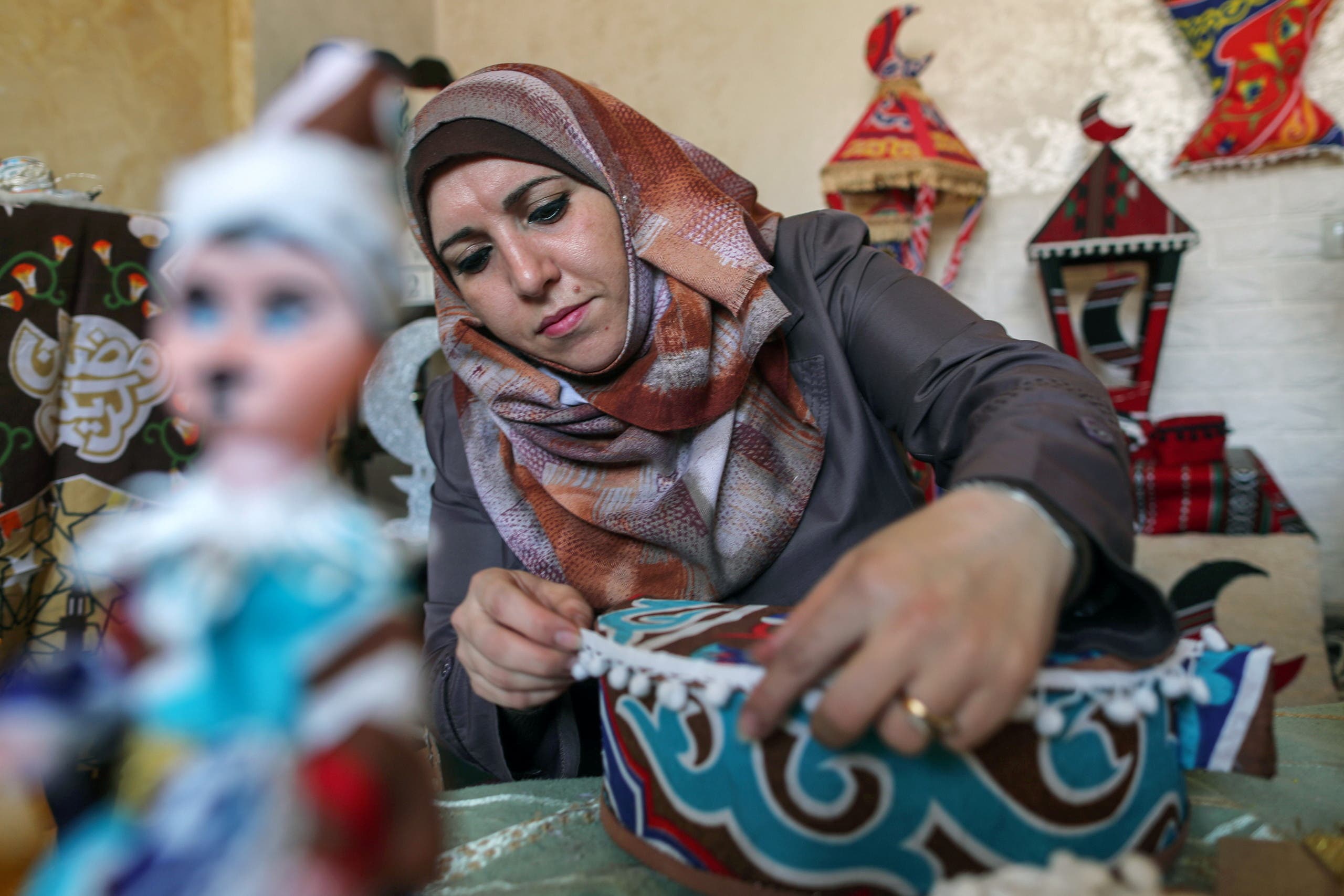 Palestinian Hanan Al-Madhoon makes decorations for sale ahead of the holy fasting month of Ramadan, at Beach refugee camp in Gaza City. (Reuters)