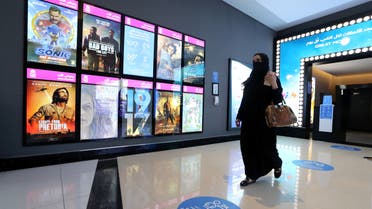 A woman wearing a protective mask walks past the movie screen board at VOX Cinema in Riyadh Park Mall, after the government lifted the coronavirus lockdown restrictions in Riyadh, Saudi Arabia June 25, 2020. REUTERS/Ahmed Yosri