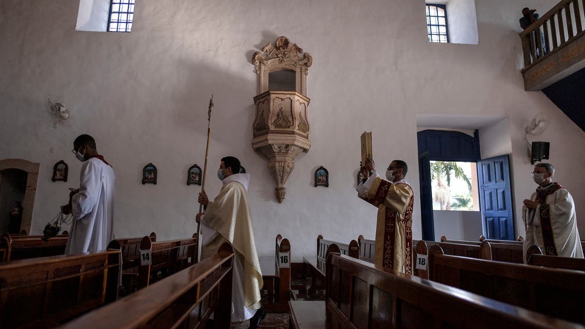 Priests wearing protective face masks as a precautionary measure against the spread of the novel coronavirus, take part in an Easter mass during Holy Week at Santo Antonio church in Mateus Leme, state of Minas Gerais, Brazil, on April 4, 2021. (File photo: AFP)