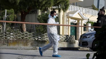 A forensic expert is seen on the road where Greek journalist George Karaivaz was fatally shot in the Alimos suburb of Athens, Greece, April 9, 2021. (Reuters)