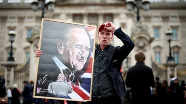 A man holds a poster depicting late Britain's Prince Philip, husband of Queen Elizabeth, who died at the age of 99, outside Buckingham Palace in London, Britain. (Reuters)