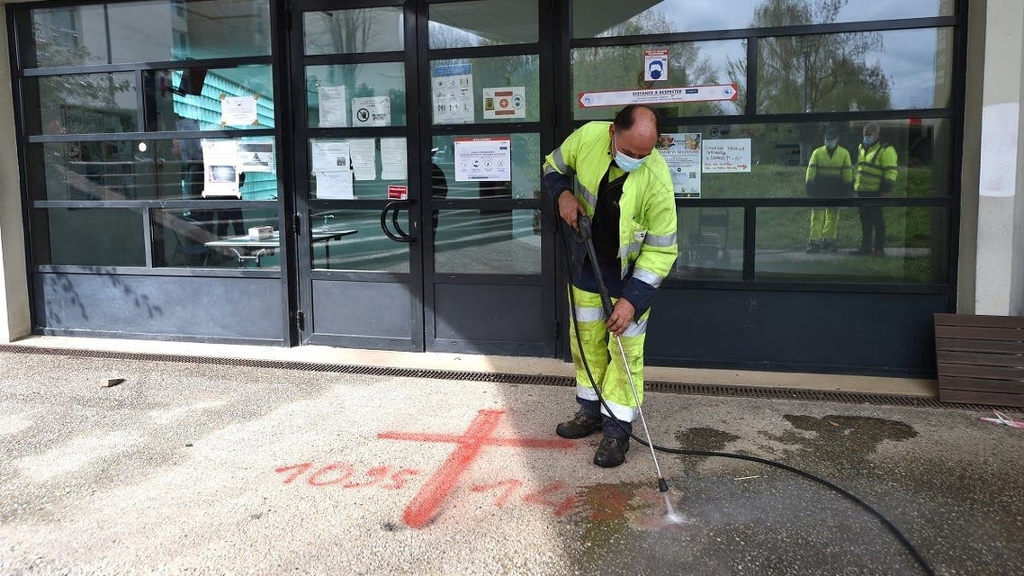 A municipal worker cleans sprayed graffiti outside the Avicenna Islamic Cultural center discovered by early morning Muslim worshippers in Rennes, western France on April 11, 2021. (Jean-Francois Monier/AFP)