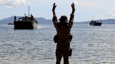 A Filipino soldier displays a hand signal to the landing ships before it docks at Motiong beach, as part of the Humanitarian Assistance and Disaster Response scenario during the Philippines and United States annual Balikatan (Shoulder-to-Shoulder) exercises in Casiguran, Philippines May 15, 2017. (Reuters)