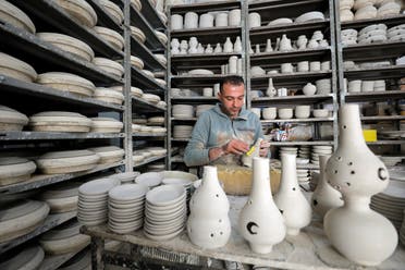 A Palestinian man works on ceramic pots for sale ahead of the holy fasting month of Ramadan, in Hebron in the Israeli-occupied West Bank on April 12, 2021. (Reuters)