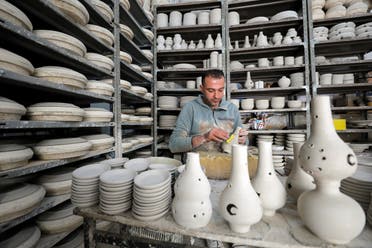 A Palestinian man works on ceramic pots for sale ahead of the holy fasting month of Ramadan, in Hebron in the Israeli-occupied West Bank on April 12, 2021. (Reuters)