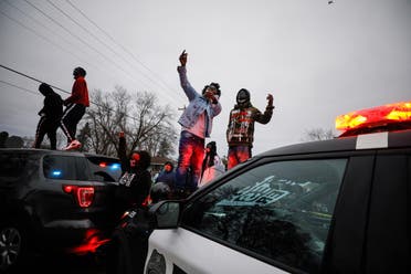 Demonstrators stand on a police vehicle during a protest after police allegedly shot and killed a man, who local media report is identified by the victim's mother as Daunte Wright, in Brooklyn Center, Minnesota, US, April 11, 2021. (Reuters)