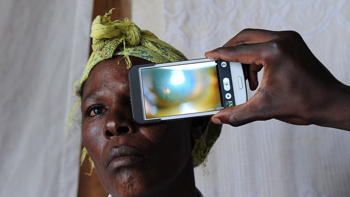 This photo shows a technician scanning the eye of a woman with a smartphone application (File photo: AFP)