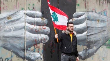 A man holds a Lebanese flag as demonstrators gather during a protest over the deteriorating economic situation, in Beirut, April 10, 2021. (Reuters)