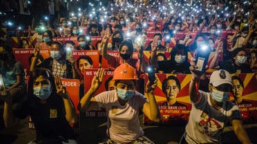 In this file photo taken on March 12, 2021, protesters hold up the three-finger salute and placards with the image of detained civilian leader Aung San Suu Kyi while using their mobile torches during a demonstration against the military coup in Yangon. Myanmar's ousted civilian leader Aung San Suu Kyi was hit with a fresh criminal charge on April 12, 2021, as the junta's tough crackdown on dissent rolls on. (File photo: AFP)