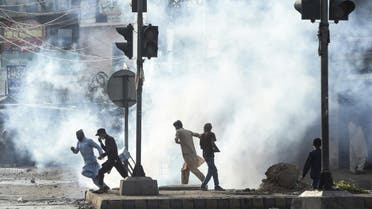 Supporters of Tehreek-e-Labbaik Pakistan (TLP) party disperse after police fired tear gas during a protest against the arrest of their leader as he was demanding the expulsion of the French ambassador over depictions of Prophet Muhammad, in Lahore on April 13, 2021. (AFP)