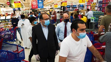 In this Sunday, April 19, 2020 photo, Majid Al Futtaim CEO Alain Bejjani, (center left), and store manager Arnaud Bouf (center), walk through heavy shopping traffic during the coronavirus pandemic in the world's busiest Carrefour supermarket, at the Mall of the Emirates in Dubai, UAE. (AP)