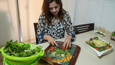 Hala Sheikh prepares Fattoush, a popular salad, at her house in Beirut, Lebanon April 13, 2021. (Reuters)