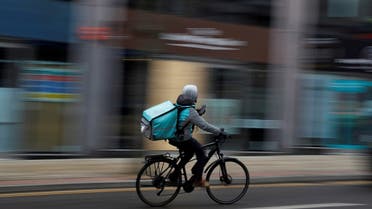 A deliveroo delivery driver cycles through the centre of Manchester, Britain, on March 8, 2021. (Reuters)