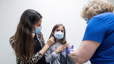 Marisol Gerardo, 9, is held by her mother as she gets the second dose of the Pfizer coronavirus disease (COVID-19) vaccine during a clinical trial for children at Duke Health in Durham, North Carolina, US, April 12, 2021. (Reuters)