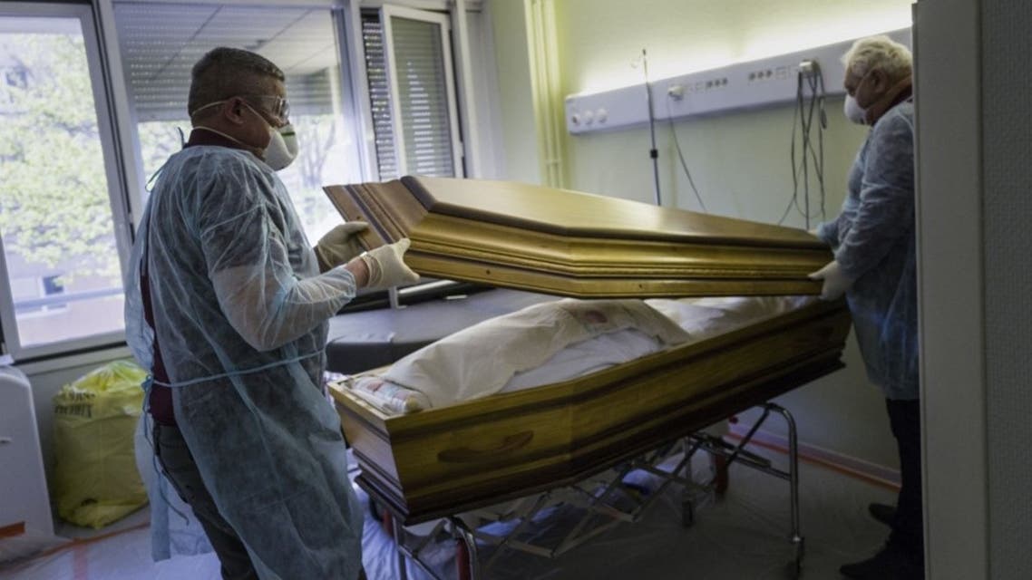 In this file photo taken on April 5, 2020, employees of the Lantz funeral company close the coffin of a victim of the Covid-19 at an hospital in Mulhouse, eastern France. (AFP)